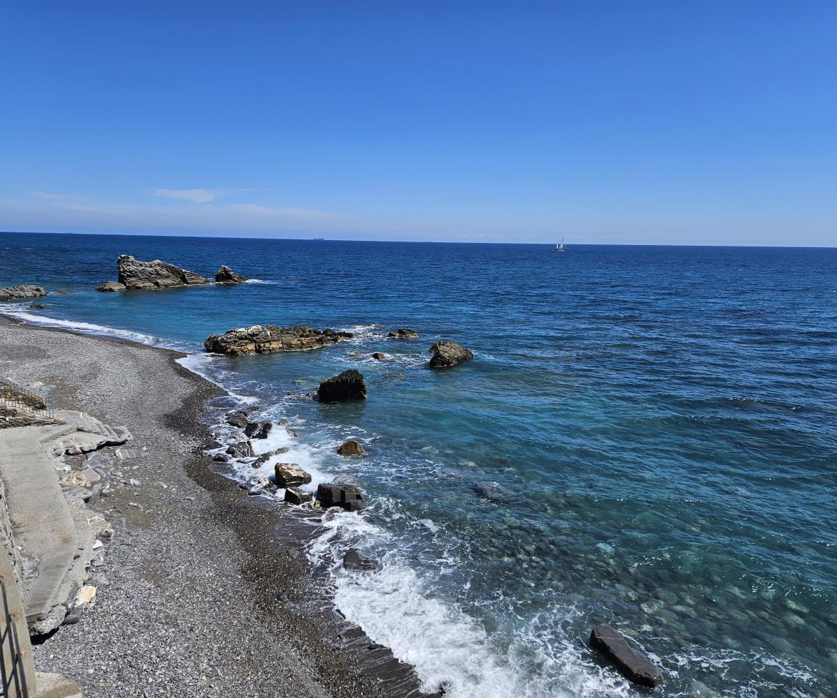 Imperia sea — beach, rocks and sailing boat